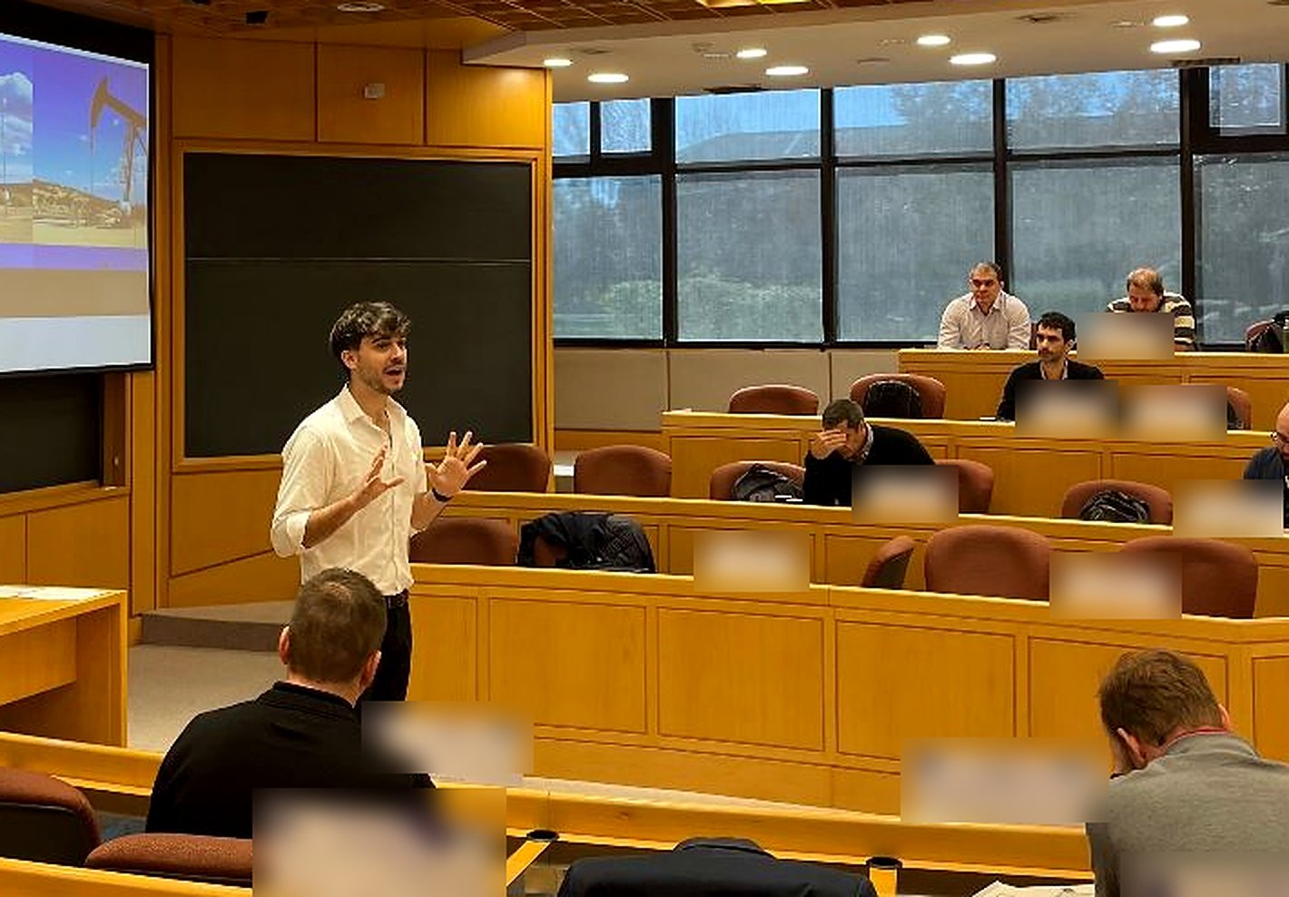 Fernando E. Batista exponiendo en un aula universitaria, con una presentación sobre gas y petróleo